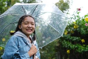 sonrisa joven divirtiéndose en la lluvia. foto