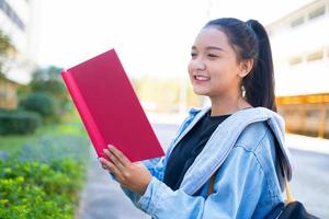 Happy student girl hold book and backpack at school, Asian girl. photo