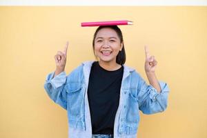 Happy student young girl with pink book on brown background. photo