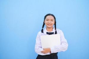 School girl holding billboard on blue background. photo