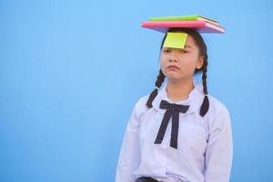 estudiante con libro y papel de nota pequeña sobre fondo azul. foto