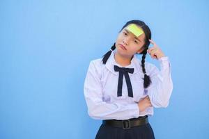 Student with book and small note paper on blue background. photo