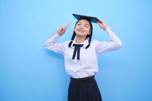 School girl holding tablet on blue background. photo