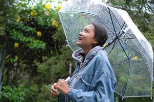 sonrisa joven divirtiéndose en la lluvia. foto