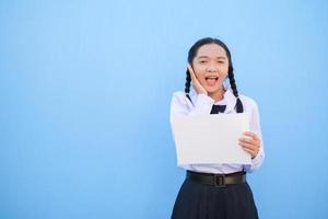 School girl holding billboard on blue background. photo