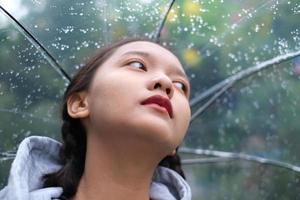 sonrisa joven divirtiéndose en la lluvia. foto