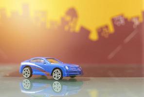 Blue saloon car toy selective focus on blur city background photo