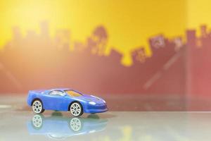 coche sedán azul juguete enfoque selectivo en el fondo de la ciudad borrosa foto
