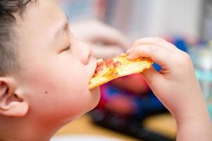 kid eats pizza