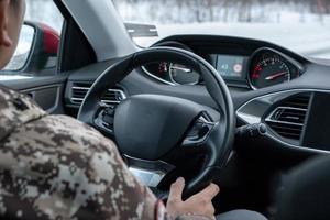 Man driving with holding steering wheel inside of modern car on the road photo