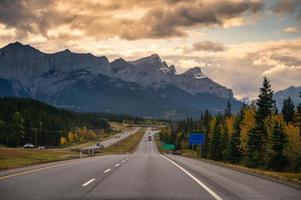 Road trip of car driving on highway with rocky mountains in the evening at Banff national park