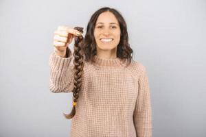 Photo of a braid of brunette hair for cancer patients held by a girl.