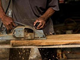 Professional technicians in the factory are using power tools to polish the wooden photo