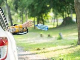 The woman threw a plastic water bottle after drinking all the water into the park area photo