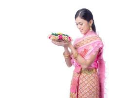 atractiva mujer tailandesa vestida con ropa tradicional tailandesa sostiene una canasta de flores foto