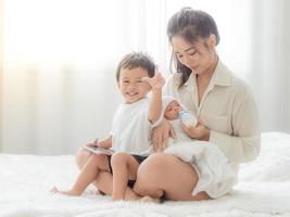 A beautiful Asian woman holds her newborn baby with love and cherish and feeds her with happiness photo