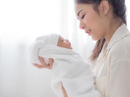 A beautiful Asian woman carried her newborn baby with happiness photo