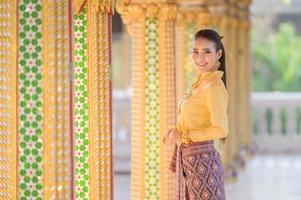 Charming Thai women in traditional Thai costumes prepare to pay homage to the Buddha in a Thai temple to pray for the Songkran tradition in Thailand photo