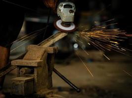 Professional technicians in the factory are using power tools to polish the metal photo