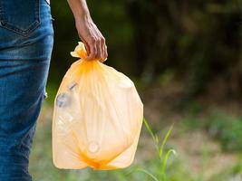 Volunteer women carry plastic bags in plastic bottles collected in public parks photo