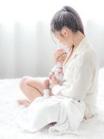 A beautiful Asian woman puts her newborn baby on her body photo