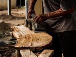 Professional technicians in the factory are using power tools to polish the wooden photo