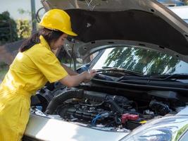 mujeres en uniformes de trabajo están midiendo los niveles de aceite del motor del automóvil foto
