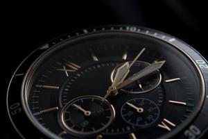 Close up of Black wrist watch with golden details photo