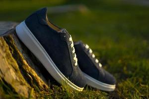 Stylish blue sports shoes with background in the park photo