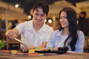 Image of young Asian couple eating dinner together photo