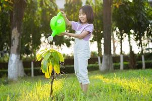 imagen de niña asiática está regando plantas foto