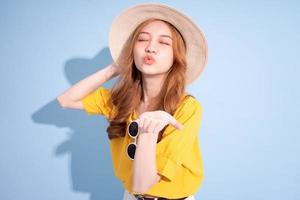 Portrait of young Asian girl on blue background, summer vacation concept photo