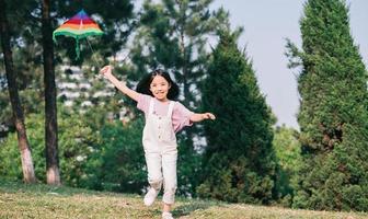 Image Asian little girl playing kite in the park