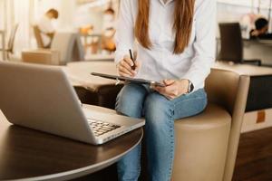 proceso de trabajo en la oficina moderna. joven gerente de cuentas trabajando en la mesa con un nuevo proyecto empresarial. teclado de escritura, usando una computadora portátil contemporánea. foto