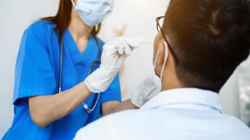 Doctor in a protective suit taking a throat and nasal swab from a patient to test photo