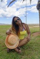 happy middle-aged woman smiling on her holidays in mallorca, with hat sunglasses and bikini, travel concept photo