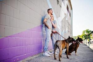 Couple in love with two dogs pit bull terrier on a walk. photo