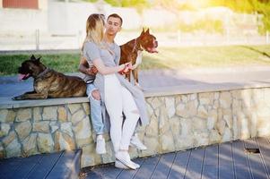 Couple in love with two dogs pit bull terrier on a walk. photo