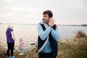 Funny man in blue hoodie with lollipop, shows different hand movements. photo