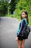 Sport girl at sportswear with backpack walking in a green park. A healthy lifestyle. photo