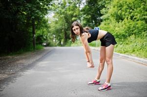 chica deportiva en ropa deportiva haciendo ejercicio en un parque verde y entrenando en la naturaleza. un estilo de vida saludable. foto