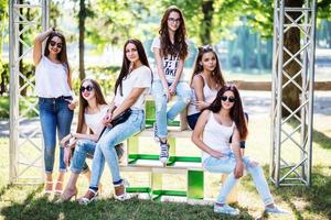 seis maravillosas chicas modelo posando en cajas de madera en el parque en un día soleado. foto