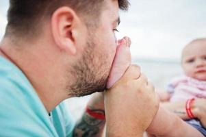 Summer vacations. Parents and people outdoor activity with children. Happy family holidays. Father, pregnant mother, baby daughter on sea sand beach. photo