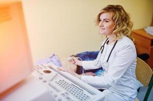 bella joven doctora haciendo ecografía diagnóstica en un paciente. foto