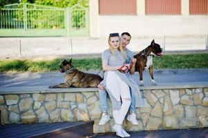 Couple in love with two dogs pit bull terrier on a walk. photo