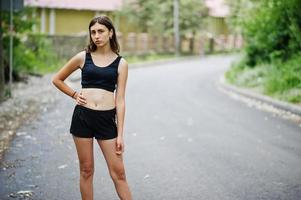 Sport girl at sportswear exercising in a green park and training at nature. A healthy lifestyle. photo