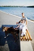 Couple in love with two dogs pit bull terrier against beach side. photo