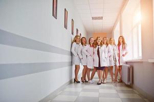 Group of gorgeous young female doctors posing in the hospital or clinique. photo