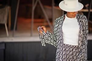 Beautiful african american woman natural makeup wear fashion clothes casual black and white dress code office style total blouse and pants suit and hat. photo