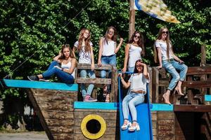 Six fabulous girl faving fun posing on a childish wooden ship in the park. photo